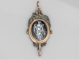 un gros plan d'un pendentif sur lequel figure le portrait d'une femme