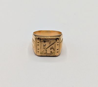 an image of a gold signet ring on a white surface