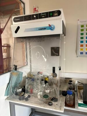 un laboratoire où s'entassent de nombreuses bouteilles sur le plan de travail