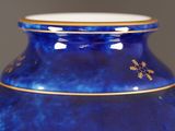 a blue vase with a gold rim on a table
