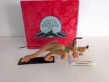 une figurine représentant un chien devant lequel se trouve un livre