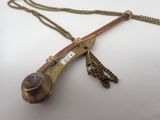 an old brass pipe with a chain attached to it on a white surface