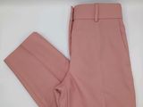 un gros plan sur un pantalon rose posé sur une surface blanche