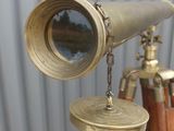 a brass telescope on a tripod with a wooden tripod stand