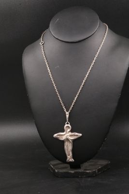 un collier en argent orné d'un ange, porté par un mannequin