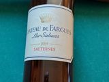 une bouteille de vin posée sur une table de billard, à côté d'une queue de billard