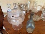 une petite table sur laquelle sont posés de nombreux objets en verre