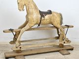 un cheval à bascule en bois muni d'une selle