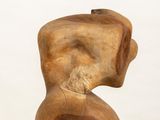 sculptures made of wood sit on a white pedestal against a white background