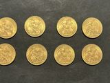 un groupe de six souverains d'or posés sur une surface noire