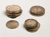 several coins sitting on top of each other on a white surface