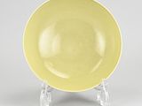 yellow plate with clear legs on a white surface