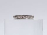 a close up of a diamond ring sitting on top of a clear glass