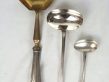 four spoons and a ladle on a table