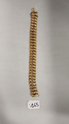 gros plan d'un bracelet en chaîne en or sur fond blanc