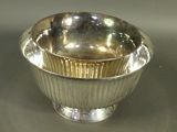 a silver bowl sitting on a table with a spoon in it