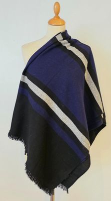 a blue and black striped ponche with fringes on a mannequin