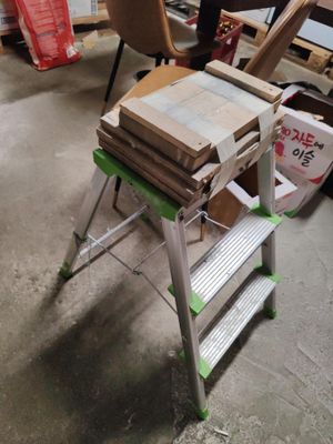 une pile de cartons posée sur un escabeau en métal