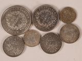 six pièces de monnaie britanniques différentes empilées les unes sur les autres sur une surface blanche