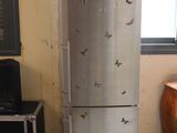 a silver refrigerator with butterflies on it in a room