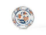 une assiette orange et bleue sur laquelle est représenté un dragon
