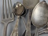 a lot of silver spoons and forks on the table