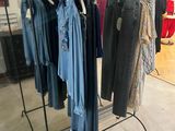 beaucoup de vêtements suspendus à une étagère dans un magasin