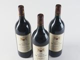 three bottles of red wine sitting on top of a white table