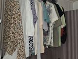 a picture of a closet with clothes hanging on a rail