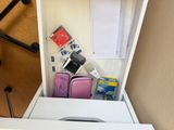 a small white box with a pink suitcase in it