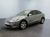 un SUV Tesla argenté garé dans une pièce au sol noir