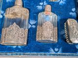 three glass bottles and a brush in a blue box