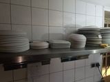 a lot of plates that are on a shelf in the kitchen