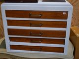 une commode blanche et marron posée sur une chaise