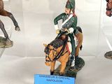 many figurines of men riding horses in a display case