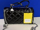 a black quilted purse with a chain strap and a tag on it