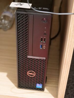 un petit ordinateur posé sur un bureau en bois