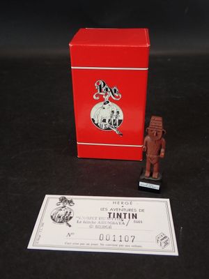 une petite boîte rouge avec une petite figurine à côté