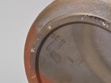 a close up of a brown vase on a table