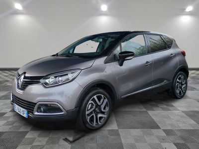 une voiture argentée est garée dans une pièce au sol en damier