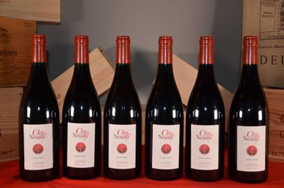 six bouteilles de vin rouge sont alignées sur une table