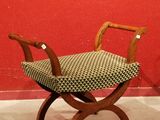 a small wooden bench with a patterned seat on it
