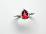 une image d'une bague sertie d'une pierre rouge en forme de poire
