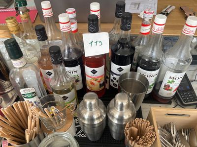de nombreuses bouteilles et cuillères posées sur une table où se trouvent de nombreux ustensiles