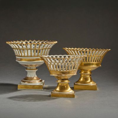 trois vases dorés et blancs posés sur une table
