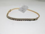 a gold bracelet with black diamonds on a white background