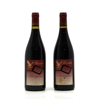 two bottles of wine sitting next to each other on a white surface