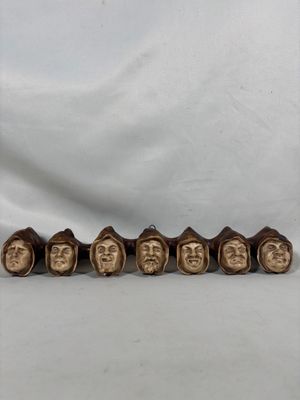 un ensemble de cinq têtes d'hommes en bois coiffées de chapeaux