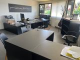 un bureau équipé d'un bureau, de chaises et d'un écran d'ordinateur