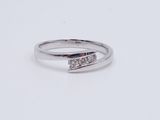 a close up of a diamond ring on a white surface